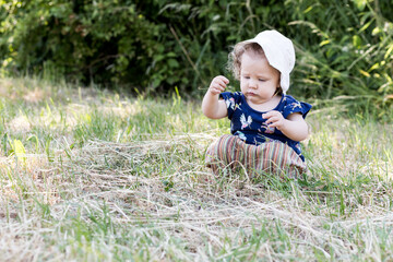 petite fille joue avec les herbes et la terre