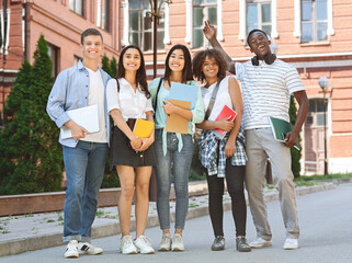 Group of happy students posing outdoors after lecture in university