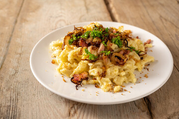 Homemade spaetzle, German egg noodles with cheese, roasted onions, bacon and breadcrumbs, served...