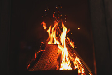 Fototapeta premium Fireplace with burning wood, closeup view. Winter vacation