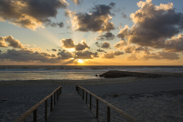 Fototapeta na wymiar Sunset through the clouds in New coast beach ,Aveiro , Portugal