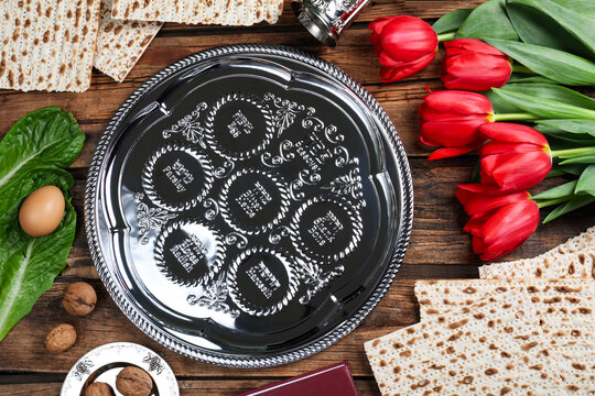 Flat lay composition with Passover Seder plate (keara) on wooden table. Pesah celebration