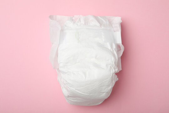 Baby diaper on pink background, top view