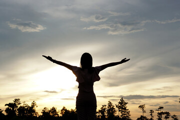 silhouette of women with both hands Get fresh air on the mountains.Freedom to live and travel