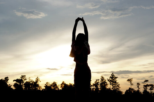 Silhouette Of Women With Both Hands Get Fresh Air On The Mountains. Freedom To Live And Travel