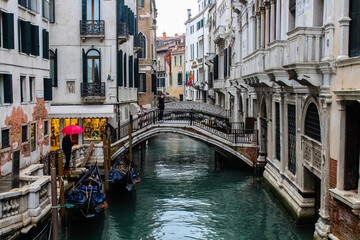 Narrow canal with gondolas and bridge in Venice. Picturesque old town, Italy.