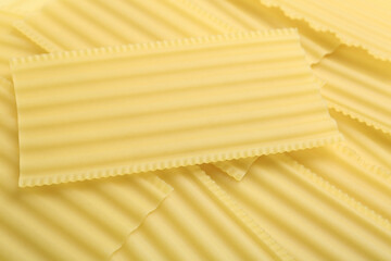 Pile of uncooked lasagna sheets as background, closeup