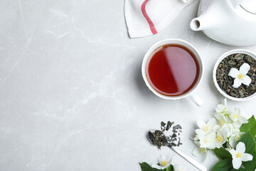 Obraz na płótnie Canvas Flat lay composition with tea and fresh jasmine flowers on light grey marble table. Space for text