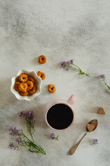 Breakfast a сup of coffee, flowers and bagels on the kitchen table with space for text