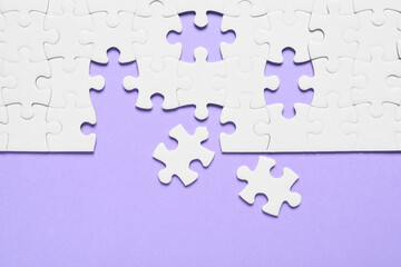 Blank white puzzle pieces on violet background, flat lay