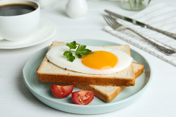 Tasty fried egg with bread and tomato on white wooden table
