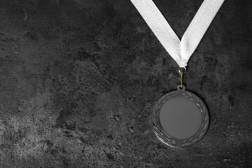 Silver medal on grey stone background, top view. Space for design