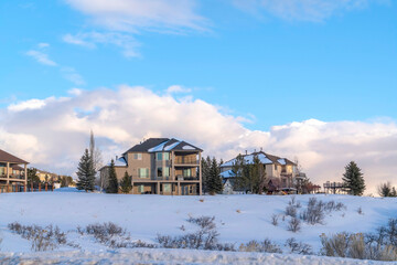 Homes against clouds and blue sky at Wasatch Mountains neighborhood in winter
