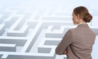 Young businesswoman in suit looking for way out of maze