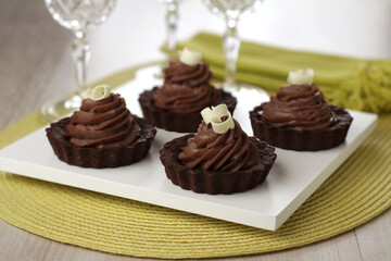 chocolate tart with chocolate cream filling and white chocolate shavings
