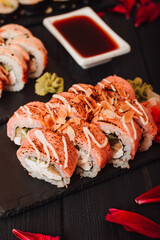 Set of sushi with wasabi, soy sauce on black stone slate background