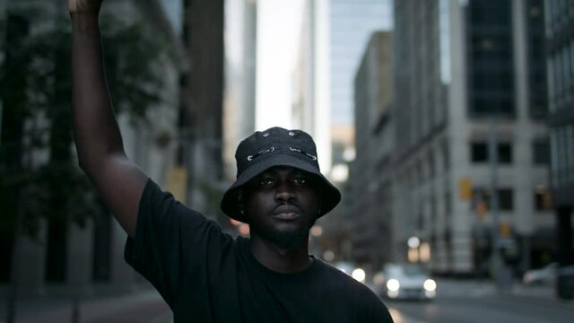 A black man raises his fist in solidarity for social and racial justice.  Peaceful protest for equality and positive change.