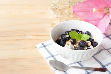 Healthy breakfast-Yogurt with muesli and berries in white bowl
