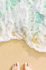 Blue ocean wave and humal foots on the sandy beach background