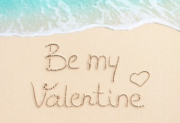 Be My Valentine handwritten text on sand, beach and soft ocean wave background