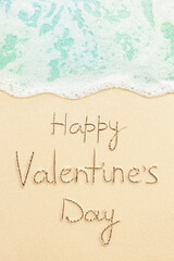 Fototapeta na wymiar Happy valentine's day written on the tropical beach, soft blue ocean wave on background
