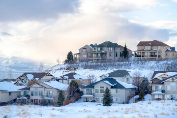 Fototapeta na wymiar Houses on snowy setting in winter with magnificent view of Wasatch Mountain