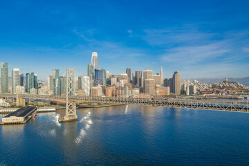 Aerial view of the San Francisco, California, skyline at sunrise. Ample copy space in blue sky. Bay bridge in foreground.