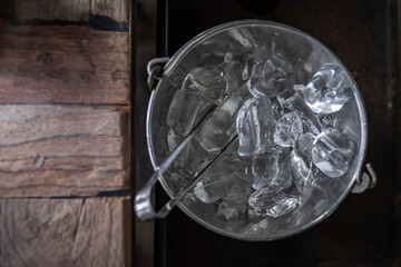 top view of ice cubes in ice bucket with ice tongs