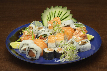 Prato com variedades de sushi, sashimi, salmão flambado e molho tarê