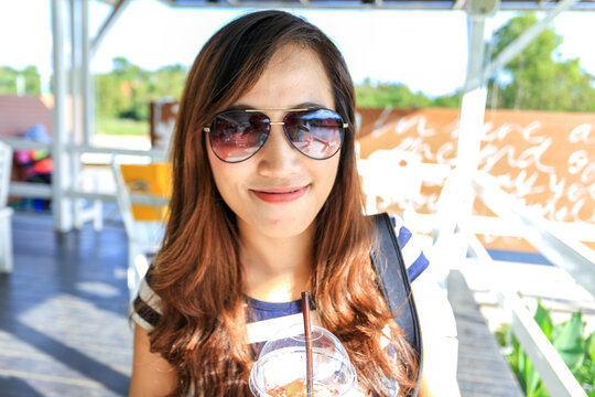 portrait of young attractive woman wearing sunglasses looking and smiling to camera 