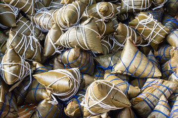 Heap of ZhongZi - traditional Chinese rice dish made of glutinous rice stuffed and wrapped in bamboo leaves in a street market, Chengdu, Sichuan province, China