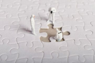 Miniature people ; Crime Scene Investigation with missing jigsaw puzzle. Selective focus.