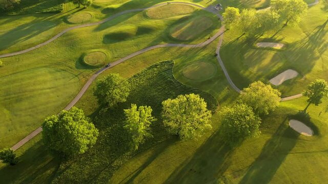 Aerial view of Golf course. Establishing shot, drone flying over golf club. Early morning, summertime, sunlight