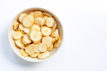 Fresh galangal slices in white bowl isolated on white