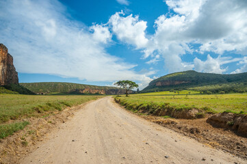 Fototapeta na wymiar African dirty road and blue sky with clouds
