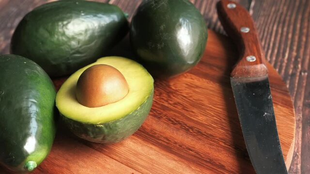 close up of slice of avocado on chopping board.