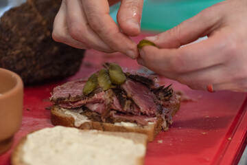 Fototapeta na wymiar slices of pastrami on bread with mayo and mustard cutting board making a recipe