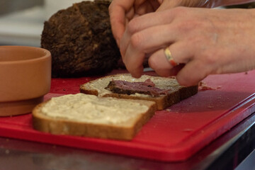 slices of pastrami on bread with mayo and mustard cutting board making a recipe
