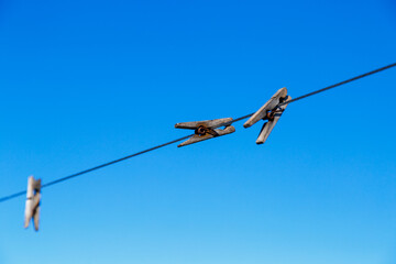 clothespin for drying clothes on a rope in different positions against a blue sky