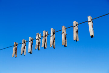 clothespin for drying clothes on a rope in different positions against a blue sky