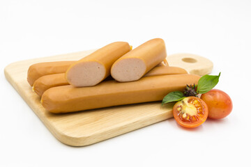 Hot Dog sausages on cutting board with tomatoes and basil on white background