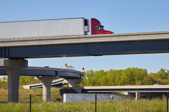 Large semi truck traveling over freeway bridge and interchanges near Minneapolis Minnesota