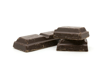 Broken black chocolate bar isolated on white background