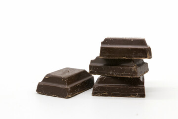 Broken black chocolate bar isolated on white background