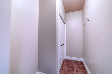 Built in cabinet inside walk in closet with wood floor and hooks on the wall