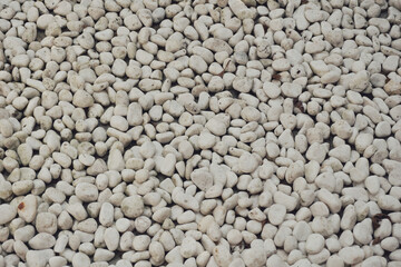 white pebbles stone texture background. Naturally polished white rock pebbles background