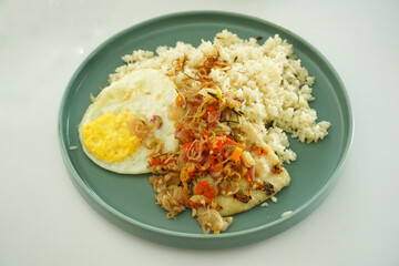 Fried rice and egg with grilled dory fish with chilli topping on a green plate.