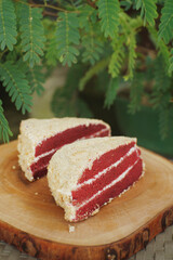 Close up of red velvet cake on a wooden plate.