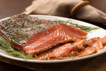 dried smoked salmon gravlax with dill on a white platter and napkin on background
