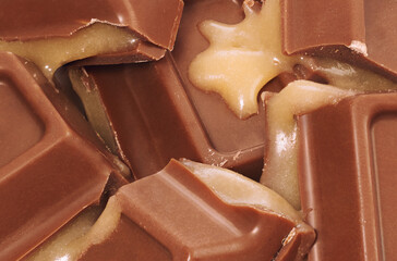 Chocolate with liquid caramel filling. Cracked pieces closeup.